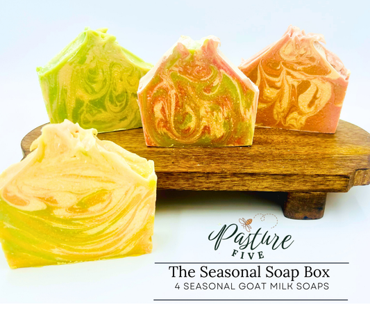 Four colorful goat milk soap bars on a wooden stand with 'Pasture Five' branding.